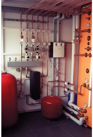 Heizraum mit Kupferleitungen und roten Ausdehnungsgefäßen